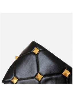 Black quilted studded leather handbag with sliding chain and protective feet. Gold finish for a refined look.