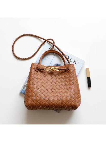 Women's woven leather shoulder bag in nude color with a gold logo.